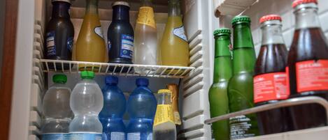 Un refrigerador lleno de diversas bebidas, como agua, jugo y refrescos.