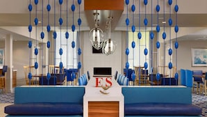 A reception area with blue seating, a reception desk, and a chandelier. - Sonesta ES Suites Flagstaff (Flagstaff)
