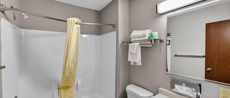 A bathroom with a bathtub, toilet, sink, and a towel rack with towels.
