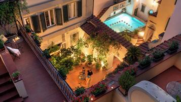 Eine Dachterrasse mit Pool, Topfpflanzen und Sitzgelegenheiten im Freien.