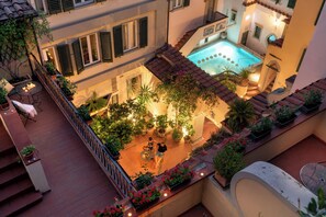 A rooftop terrace with a swimming pool, potted plants, and outdoor seating. - Rivoli Boutique Hotel (Florence)