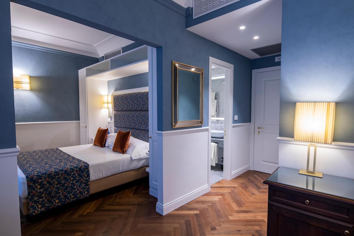 Une chambre à coucher avec un lit, une table de chevet et un miroir.