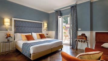 A bedroom with a bed, a chair, a table, and a view of the outside.
