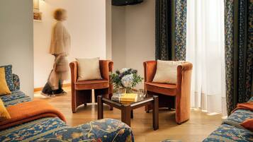 Een woonkamer met twee fauteuils, een salontafel en een bank.