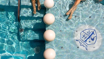Une piscine à l’eau claire, un plongeoir et un logo au fond de la piscine.