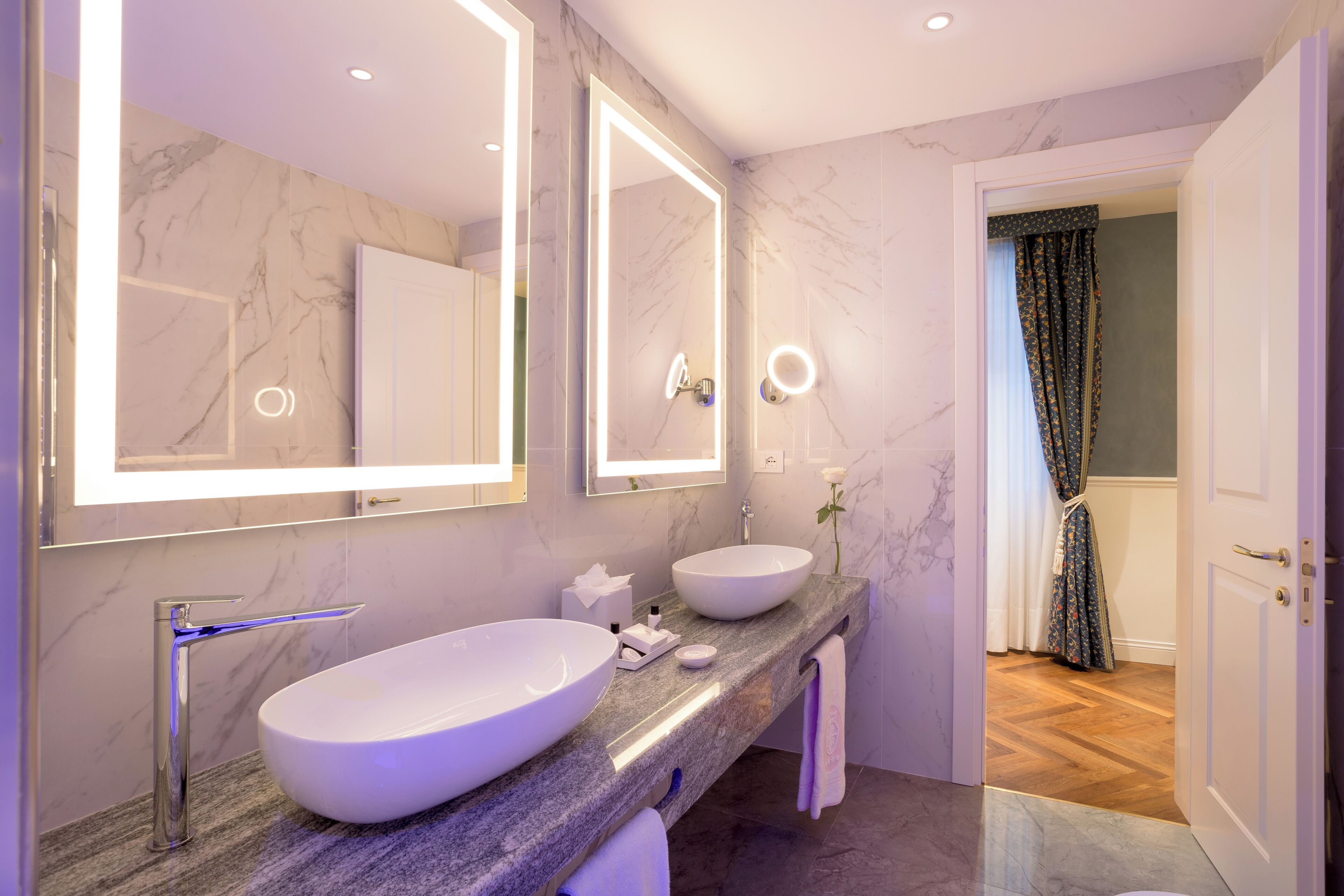 Un baño con dos lavabos, un espejo y una cortina de ducha.