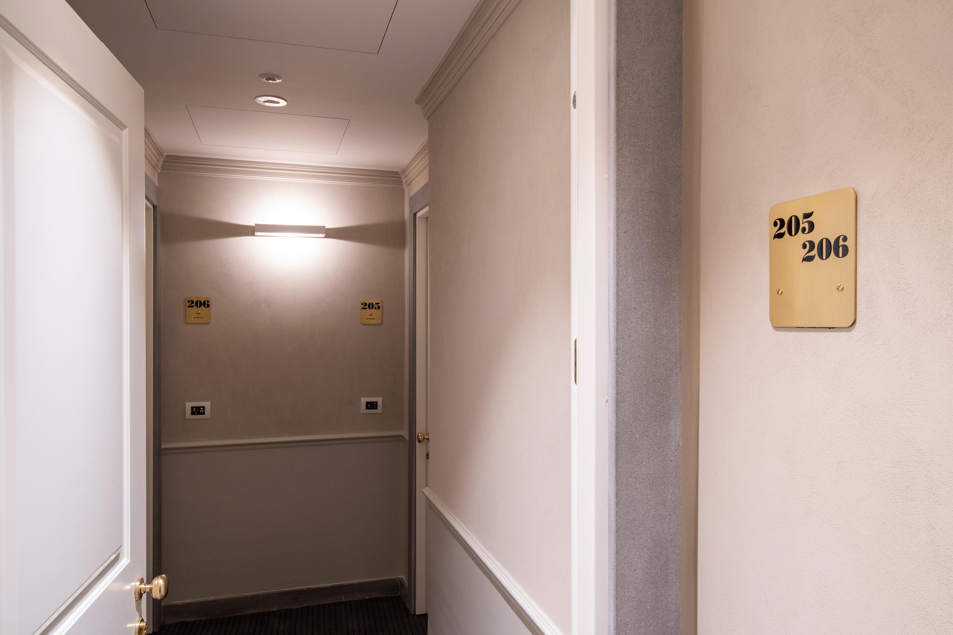 En gang med døre nummereret 205 og 206, der indikerer et hotel eller et lejlighedskompleks.