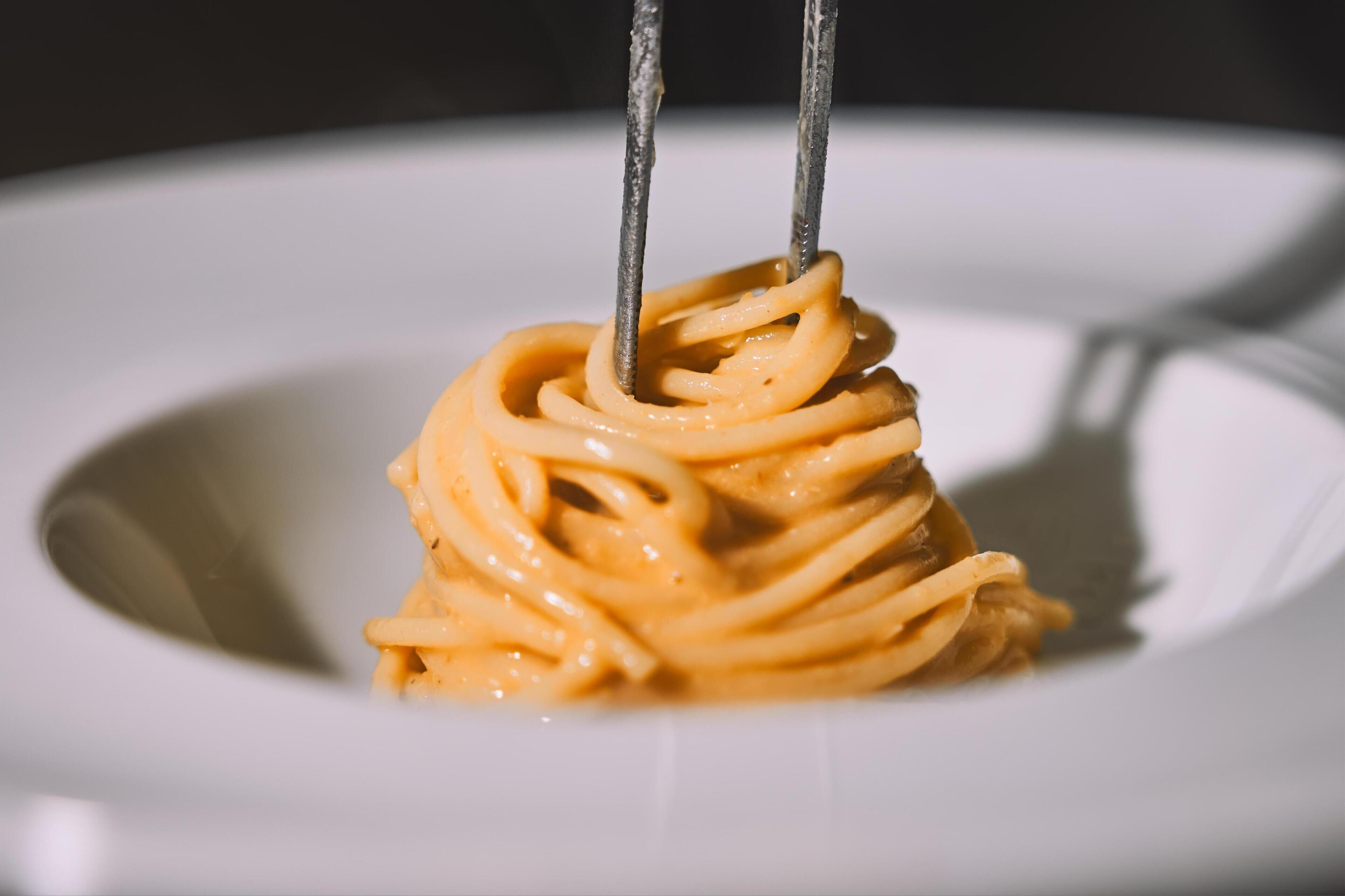 A close-up of a plate with a serving of spaghetti.