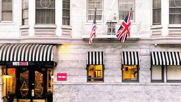 A building facade with a storefront labeled "WHITE SWAN" and two flags, one American and one British.