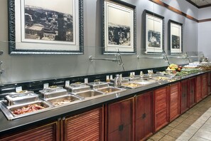 A buffet setup with multiple food stations and framed pictures on the wall. - DoubleTree by Hilton Hotel Tallahassee (Tallahassee)