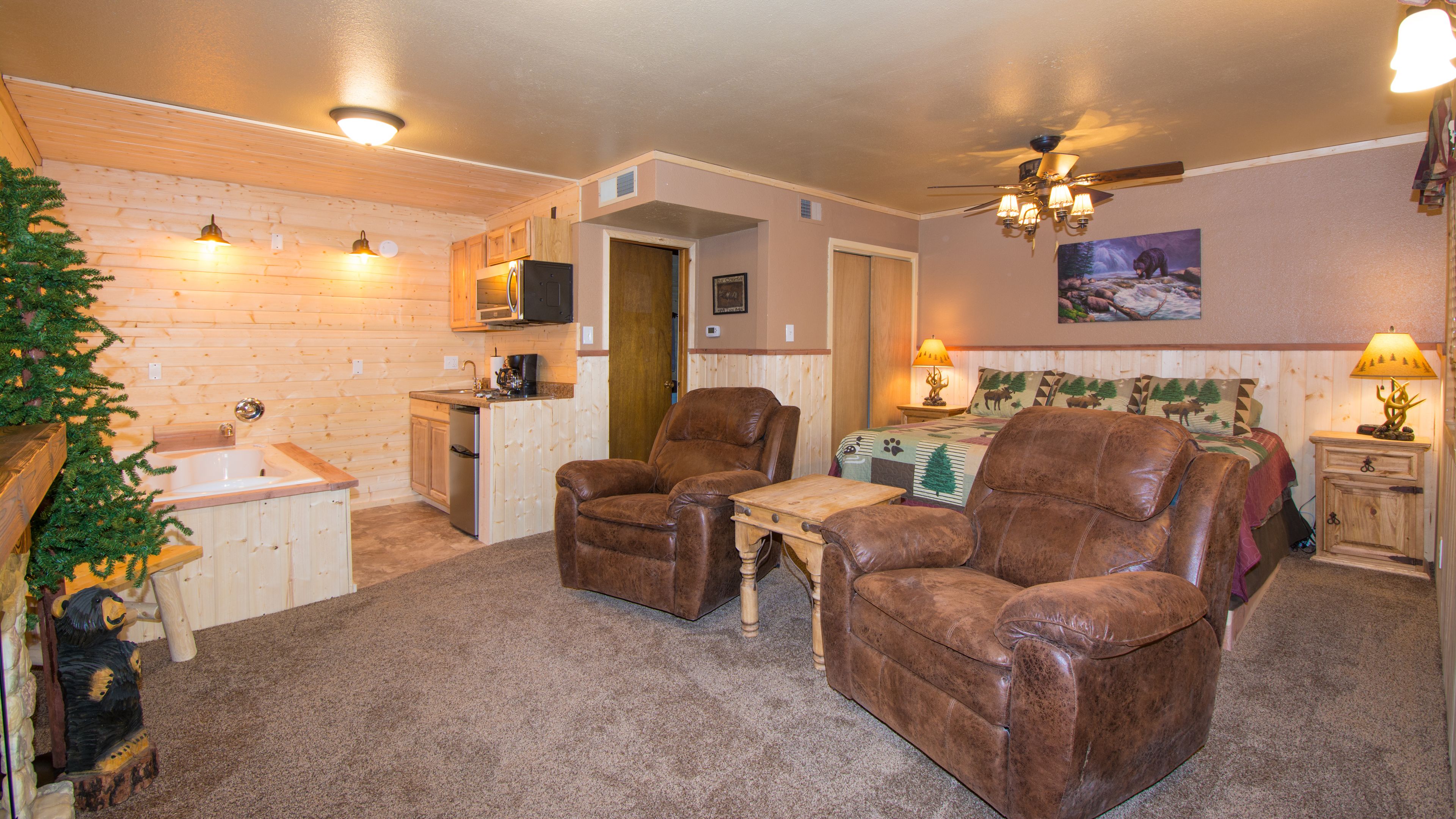 A cozy room with a kitchenette, a dining area, and a bedroom.