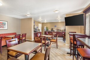 Um restaurante com cabines, mesas e um espaço de bar.