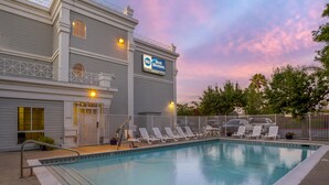 A pool area with lounge chairs and a sign for Best Western.