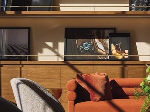 A modern living room with a sofa, a coffee table, and framed artwork on the wall. - Row NYC (New York)