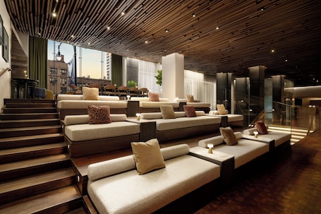 A modern interior with tiered seating, a staircase, and a view of the city.