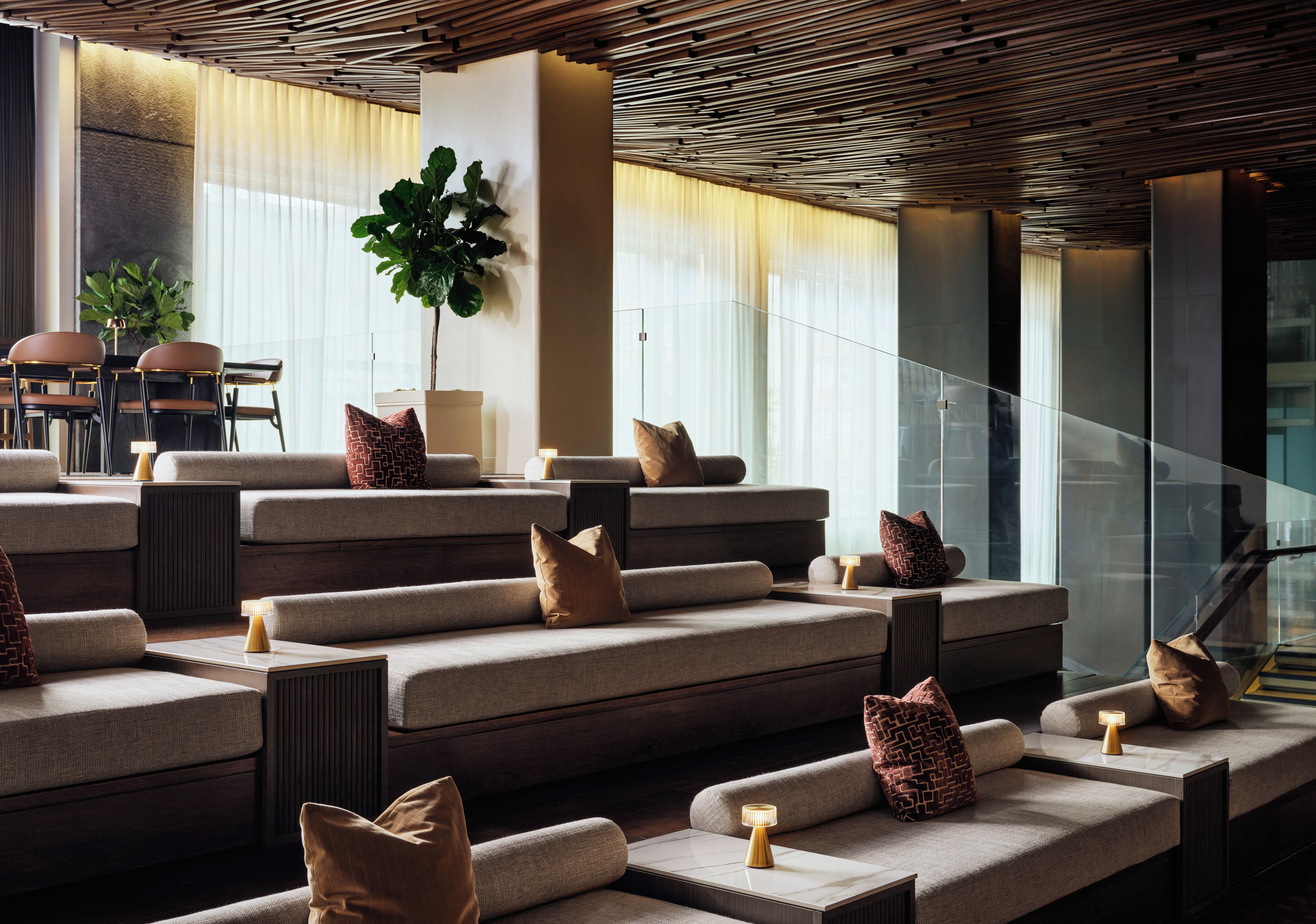 A modern interior with tiered seating, a staircase, and a view of the outdoors.