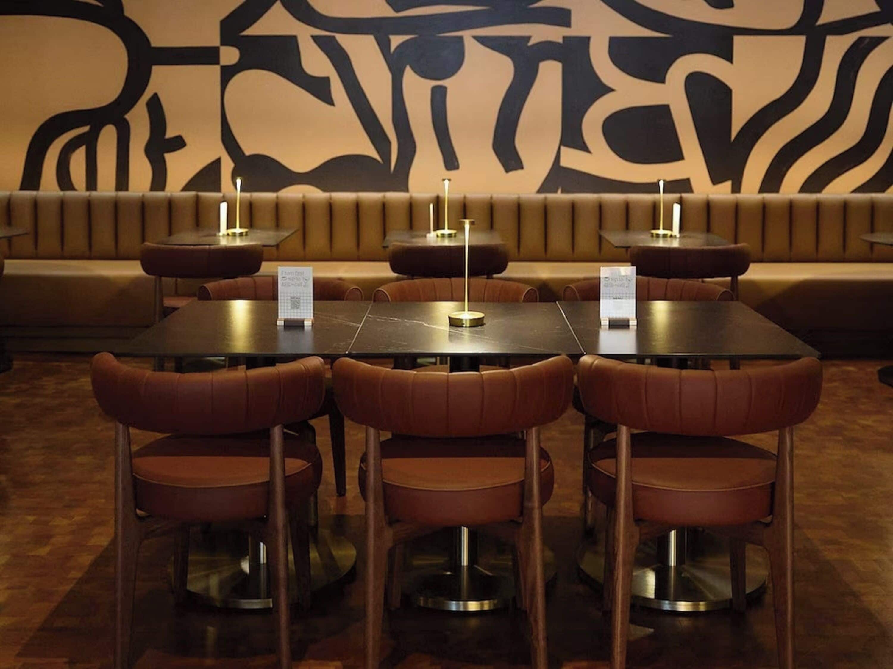 A restaurant with booths and tables, each with a menu stand.