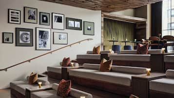 A modern interior with a staircase, seating area, and wall-mounted artwork.