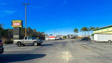 A parking lot with a Super Inn sign, a U-Haul truck, and a few cars.