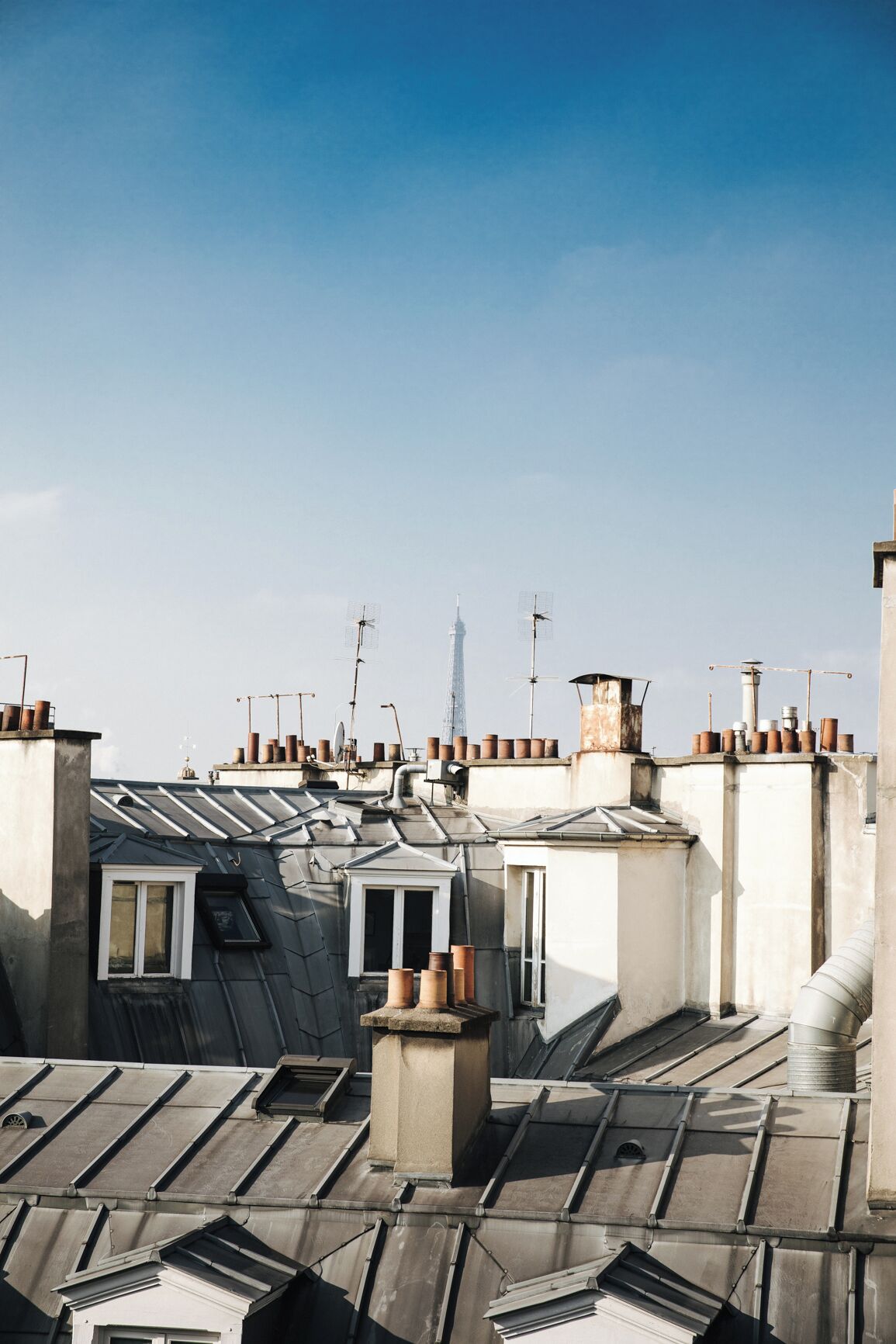 Une vue depuis le toit, avec de nombreux bâtiments, dont une tour imposante en arrière-plan.