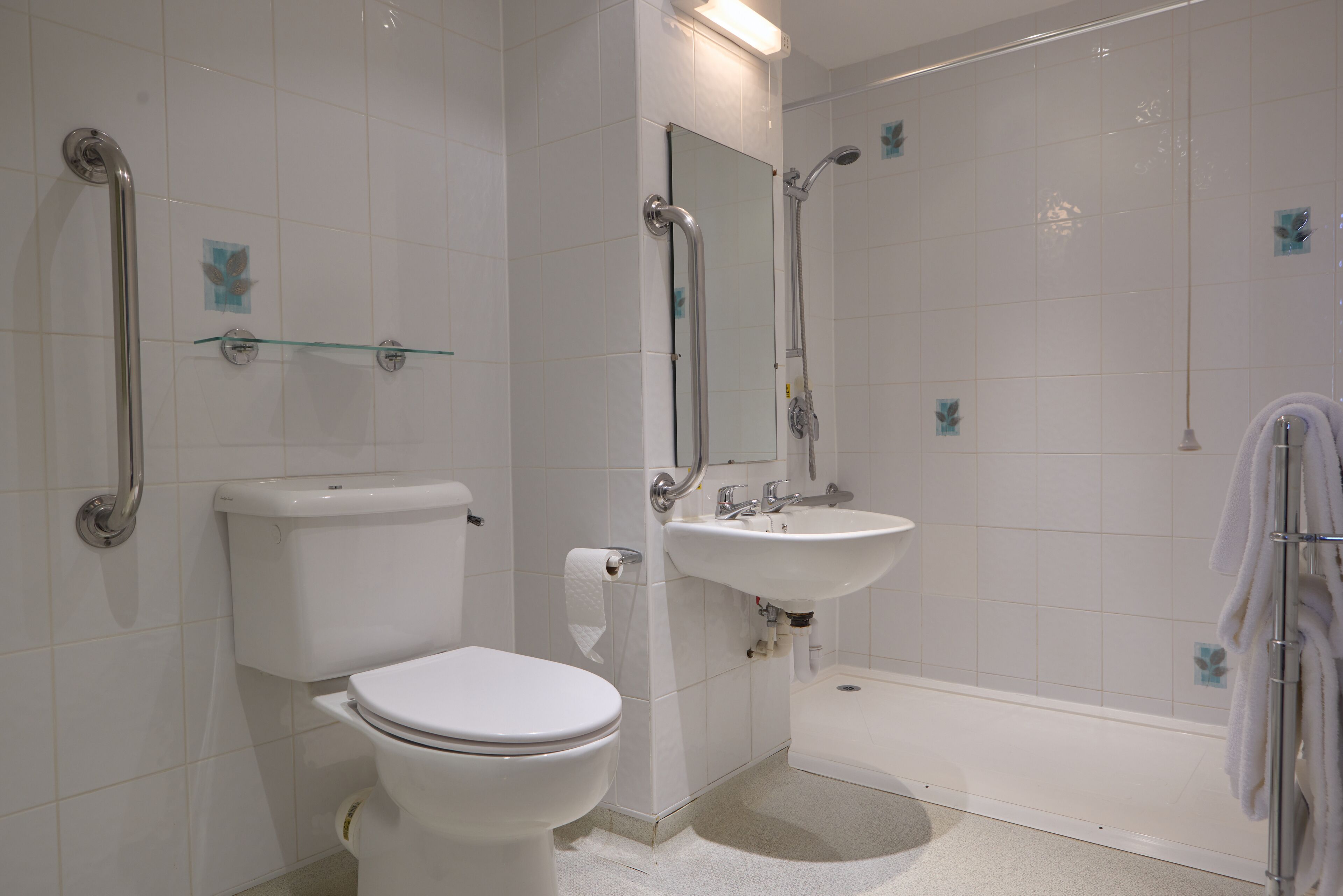 A bathroom with a toilet, sink, and shower.