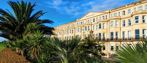 A large, multi-story building with a classic architectural style, featuring numerous windows and balconies.