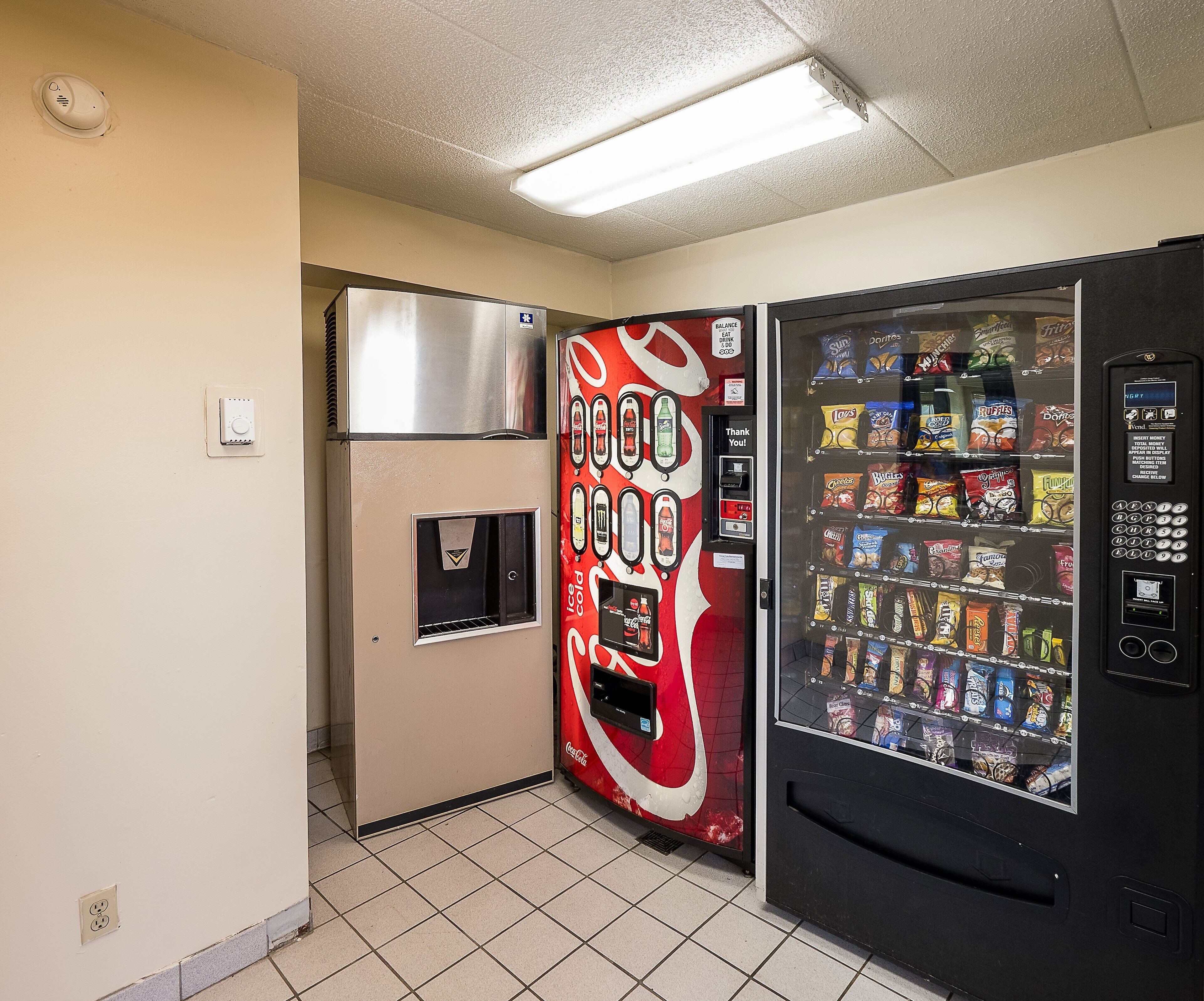 Máquina expendedora con logotipo de Coca-Cola, un refrigerador y dispensador de agua.