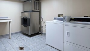 A commercial laundry area with a stainless steel dryer, a water dispenser, and a control panel. - Red Roof Inn Cincinnati East - Beechmont (Cincinnati)