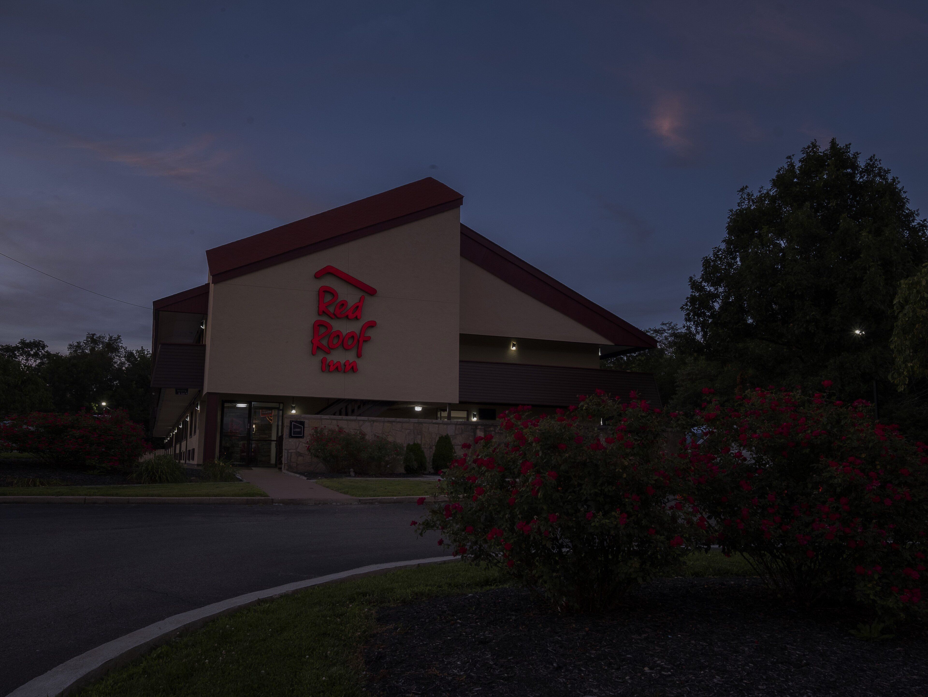 A Red Roof Inn building with a prominent red logo, a flat roof, and a simple facade.