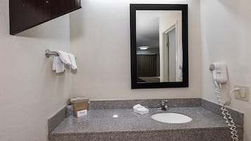 Ein Badezimmer mit einer Granitplatte, einem Waschbecken, einem Fön und einem Handtuchhalter.
