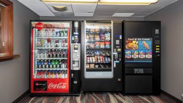 A row of vending machines with various beverages and snacks.