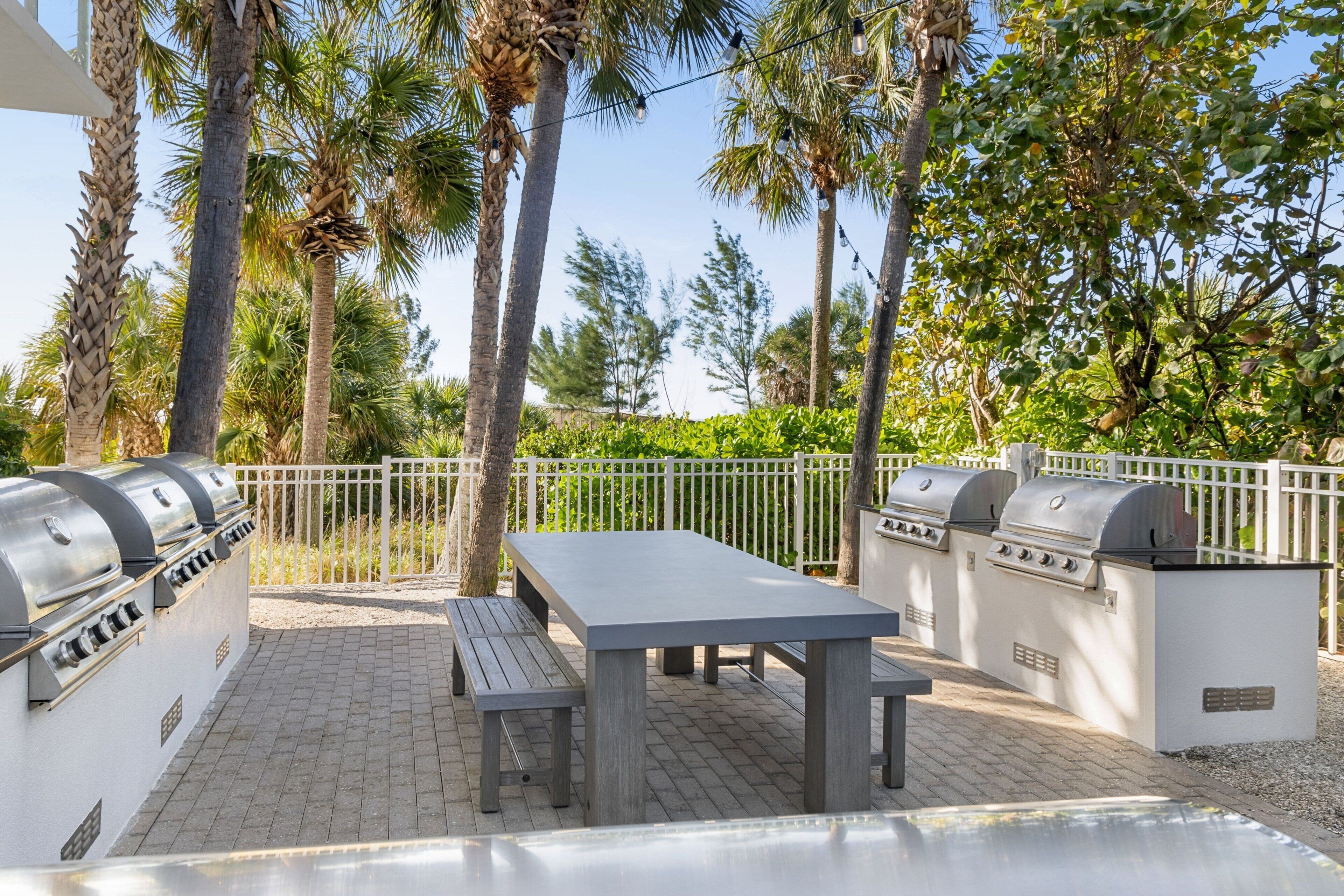 Un patio al aire libre con una parrilla, una mesa y bancos.