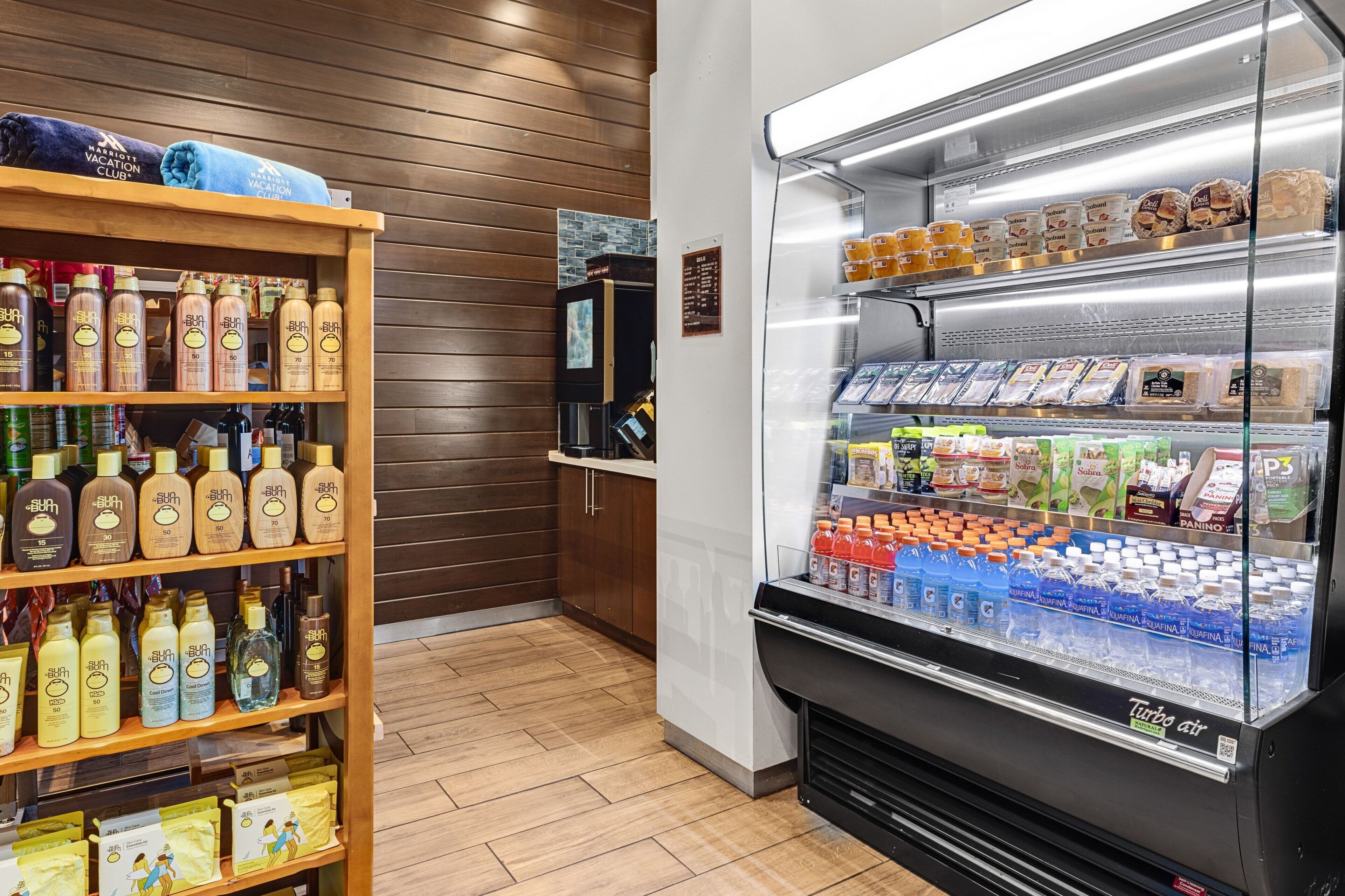 A hotel lobby with a self-service beverage station and a shelf stocked with toiletries.