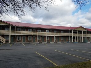 Guests can enjoy a convenient stay at this two-story motel with multiple windows and doors, offering easy access to the parking lot with marked spaces.