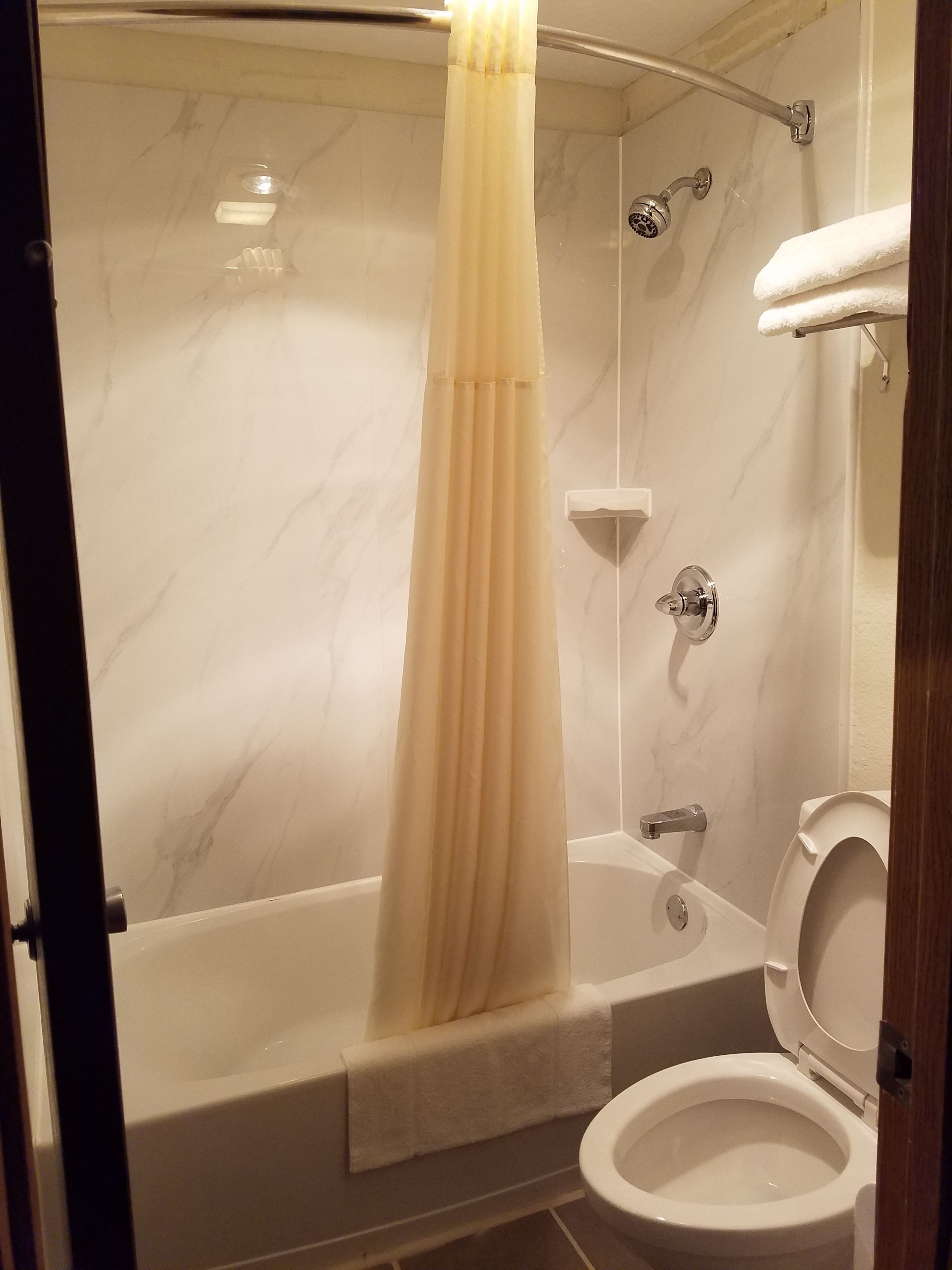 Un baño con bañera, ducha e inodoro.