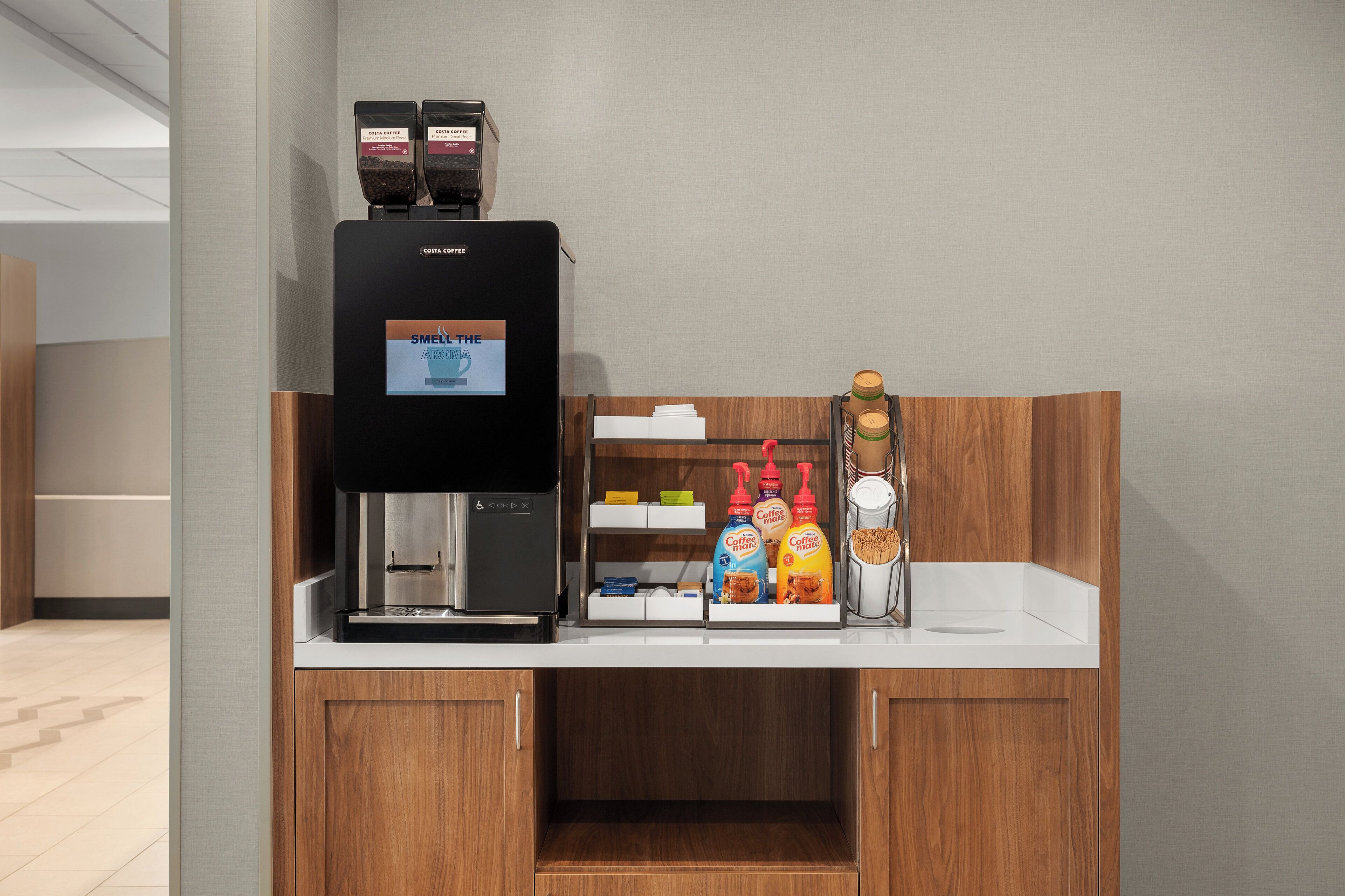 Eine Kaffeestation mit Kaffeemaschine, verschiedenen Kaffeesorten und einer Auswahl an Kaffeebohnen.