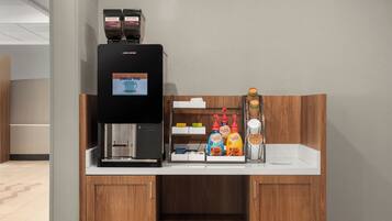 Eine Kaffeestation mit Kaffeemaschine, verschiedenen Kaffeesorten und einer Auswahl an Kaffeebohnen.