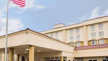 Ein Hotel mit überdachter Eingangspartie, mehreren Fenstern und einer amerikanischen Flagge.