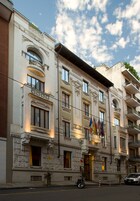 Un edificio storico con decorazioni architettoniche elaborate, numerosi balconi e bandiere.