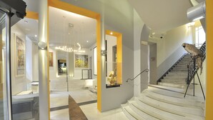 A modern interior with a staircase, a golden statue, and a security camera. - Art Hotel Boston (Turin)