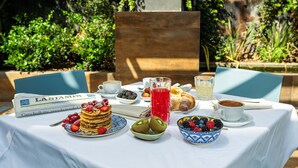 A breakfast table with pancakes, berries, a croissant, and coffee. - Art Hotel Boston (Turin)