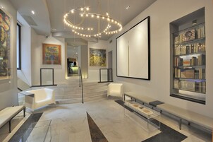 Ein modernes Interieur mit Treppe, Sitzbereichen und Kunstwerken an den Wänden.
