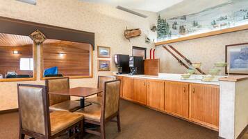 Un restaurante con mobiliario de madera, una barra con cuencos y un cuadro de un paisaje nevado.