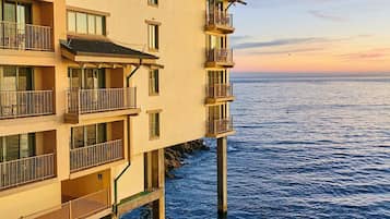 A multi-story building with balconies overlooking a body of water.