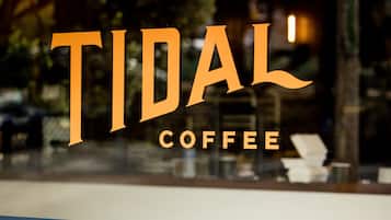 Letrero de Tidal Coffee con fondo azul y letras doradas.