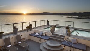 A rooftop terrace with a pool, seating areas, and a view of the sunset over the water. - Monterey Plaza Hotel & Spa (Monterey)