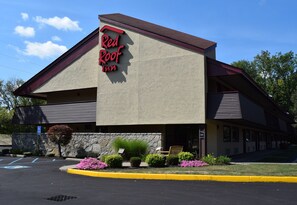 A Red Roof Inn with a stone facade, a visible entrance, and a parking lot with marked handicapped spaces. - Red Roof Inn Utica (Utica)