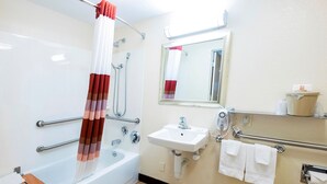 Une salle de bain avec une baignoire, un lavabo, un miroir et une douche.