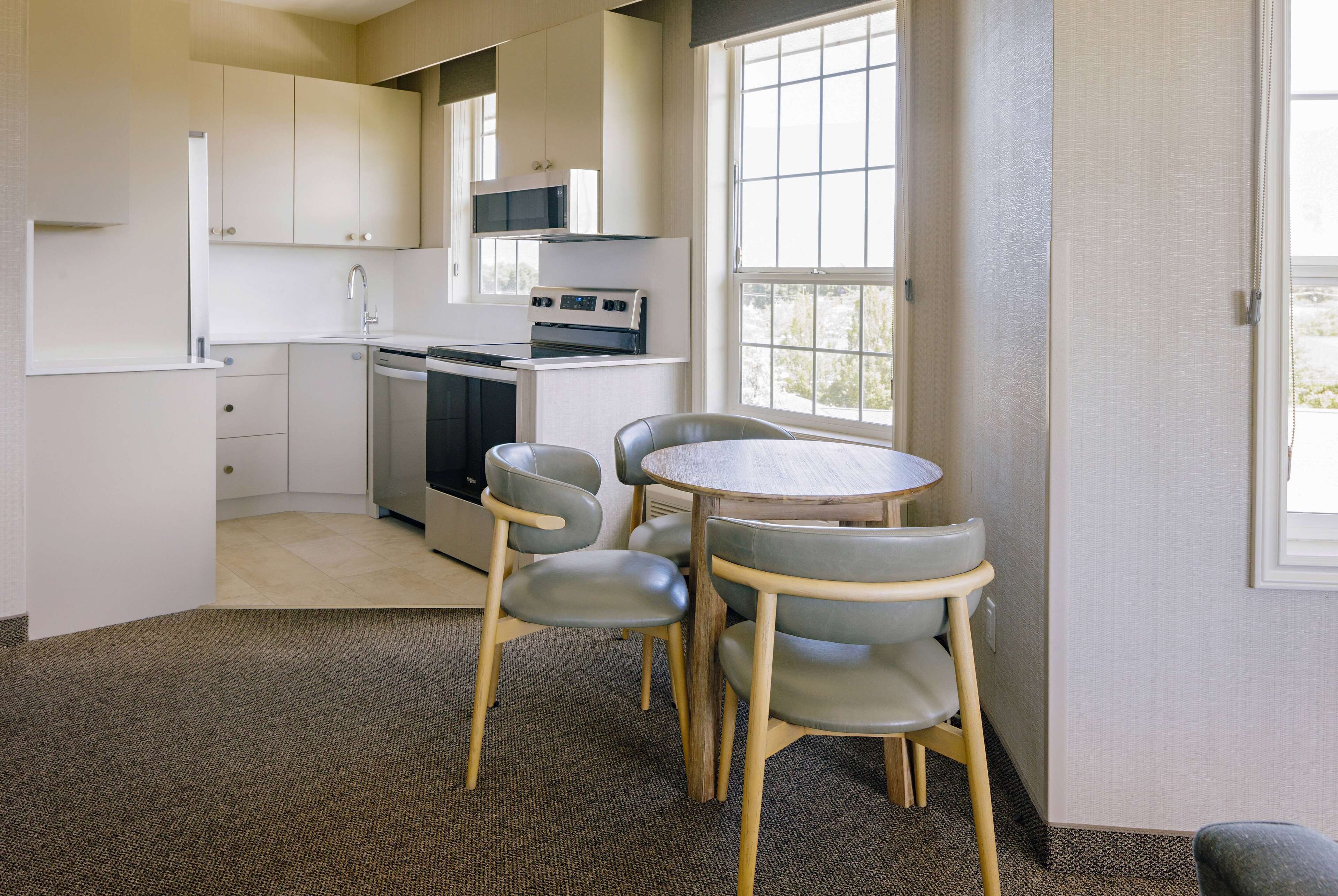 A compact kitchen with a dining area, including a microwave, oven, and sink.