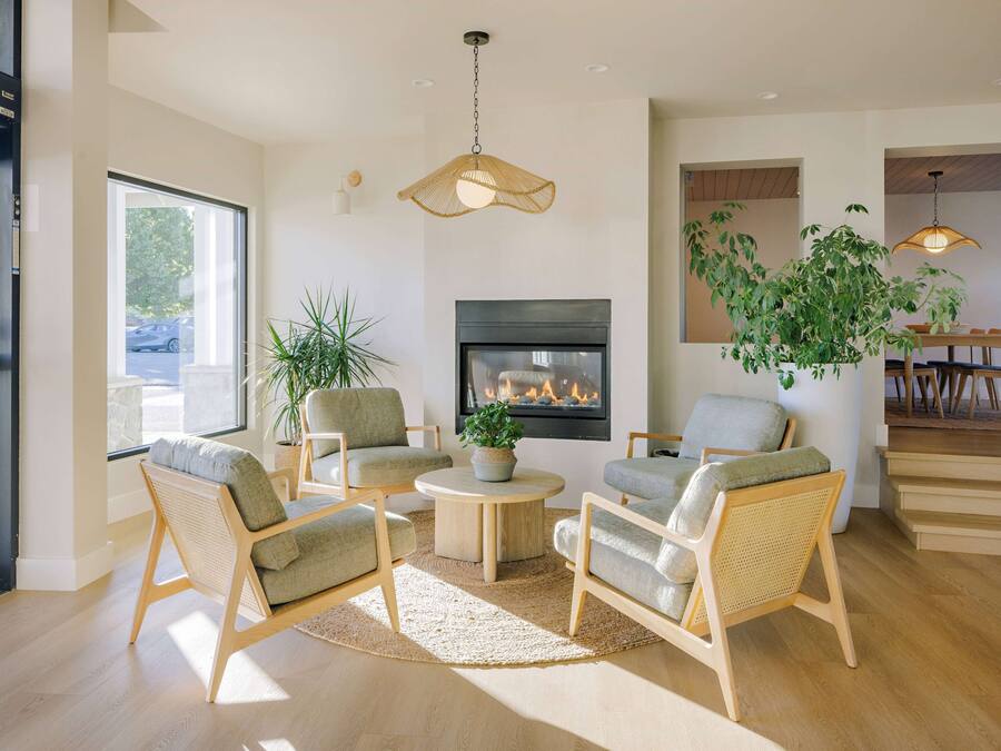 A modern living room with a fireplace, comfortable seating, and a dining area.